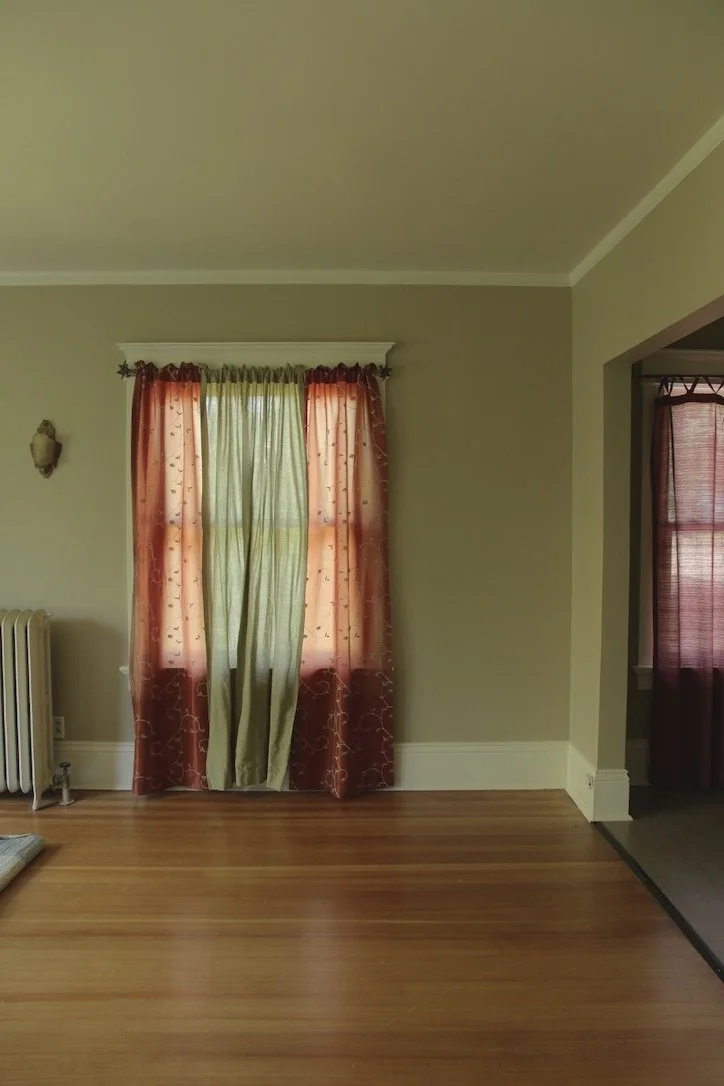 Living room brought to life with a rich natural green interior and texturally rich with curtains